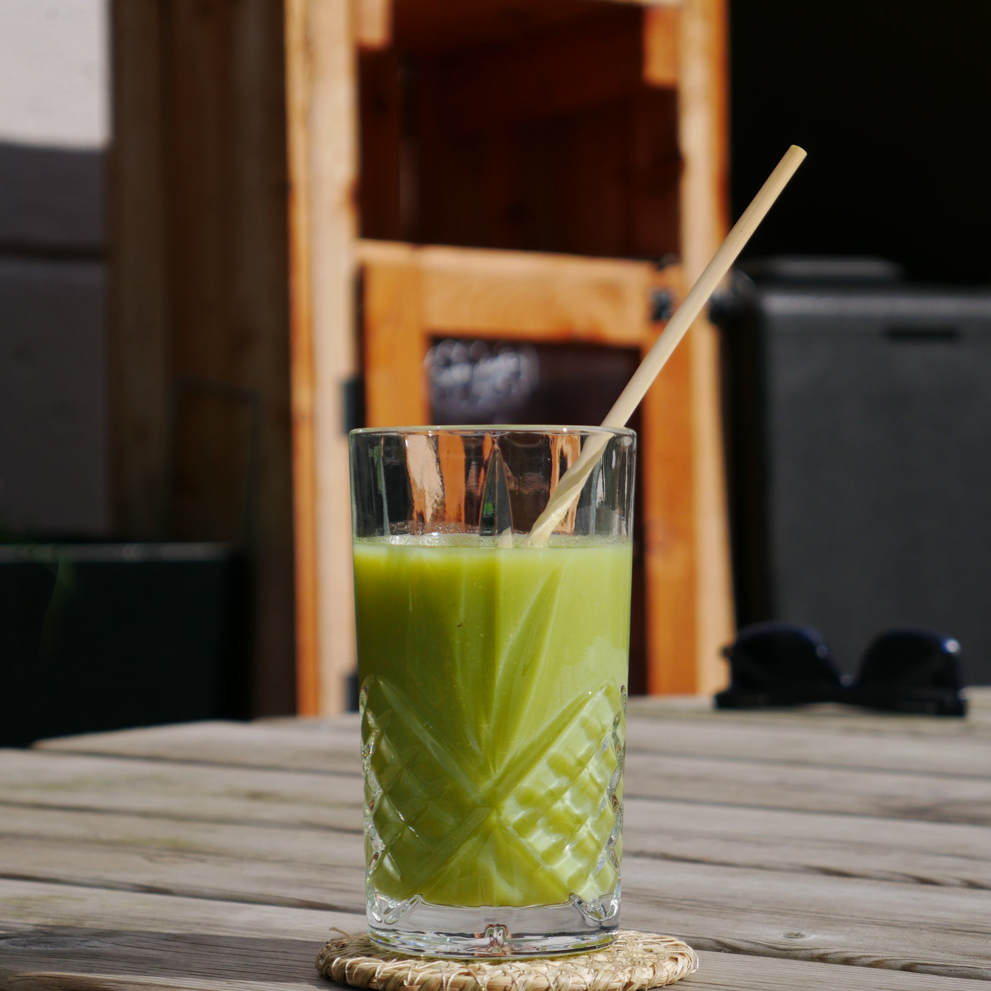 wheat drinking straw in a glass of green juice.